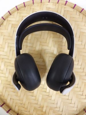 deux casques audio noirs posés sur un plateau en bambou