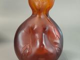 a brown glass vase with a design on it