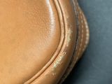 a close up of a brown leather bag on a table