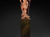 a bronze statue of a man holding a spear on a pedestal