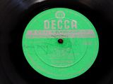 an old record with a green label on it sitting on top of a table