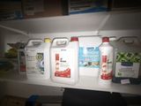 trois bouteilles de produit nettoyant sur une étagère dans un placard