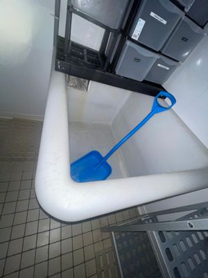 une pelle bleue posée dans une baignoire