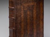 un vieux livre relié en cuir, dont la couverture est ornée d'un motif décoratif