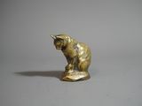 un gros plan sur une figurine représentant un chat posée sur une surface blanche