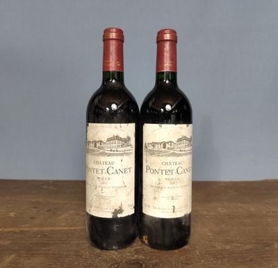 two bottles of wine sitting on top of a wooden table