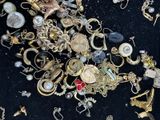 a pile of gold and silver jewelry on a black surface