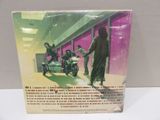 vinyl album cover of a man on a motorcycle and a woman on a scooter in front of a building
