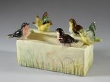 trois oiseaux perchés sur une jardinière en céramique