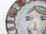 a picture of a painting on a plate with a face on it
