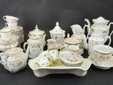 a lot of white and gold china on a table