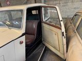 two old cars parked next to each other in a garage