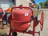 an image of a red cement mixer in front of a house