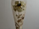 a glass vase with a flower inside of it on a table