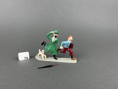 two figurines of a man and a dog on a table