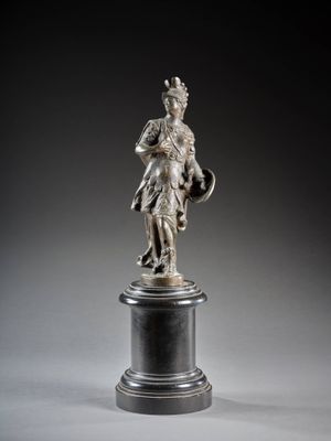 une statue en argent représentant un homme tenant un bouclier et un bouclier