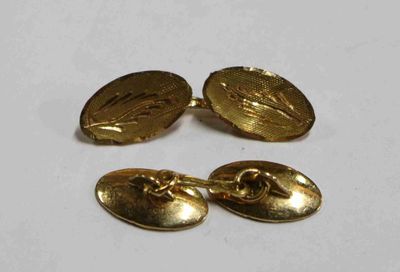une paire de boutons de manchette dorés et une paire de boutons de manchette dorés