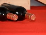 two bottles of wine sitting on a red table