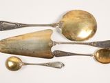 five spoons and two spoons on a white surface