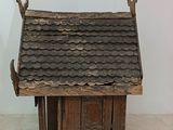 a small wooden house with a roof made of wood