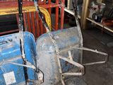 un petit tracteur bleu et une remorque bleue dans un garage