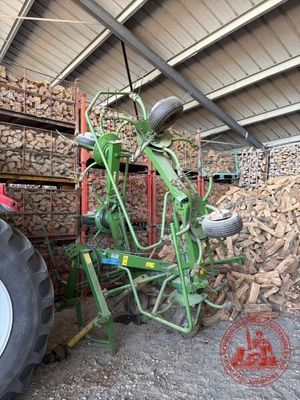un tracteur garé devant un tas de bois