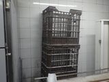 a stack of crates sitting in a kitchen next to a refrigerator