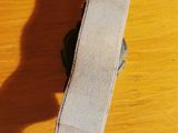 a watch sitting on a wooden table with a white strap