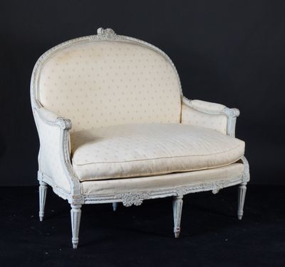 une chaise blanche de style ancien, avec un dossier et des accoudoirs rembourrés de blanc
