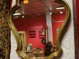 a mirror hanging on the wall next to a red wall