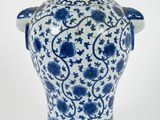 un vase bleu et blanc orné de fleurs bleues