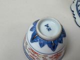 a blue and white vase sitting on a table next to a plate