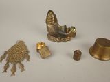 a gold figurine next to other items on a white surface