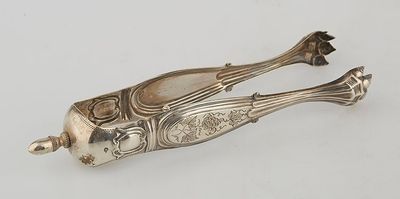 an antique silver plated fish shaped object on a white surface