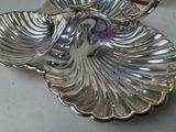 a silver plate with a shell on it on a table