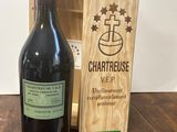 une bouteille de vin à côté d'une caisse en bois sur une table