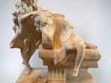 statue of a man sitting on a bench with a book