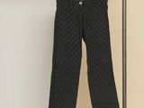 un pantalon noir suspendu à un portant devant un mur blanc