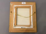 an old picture frame with a yellow ribbon hanging from it ' s side