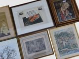 many framed pictures on the wall of a room
