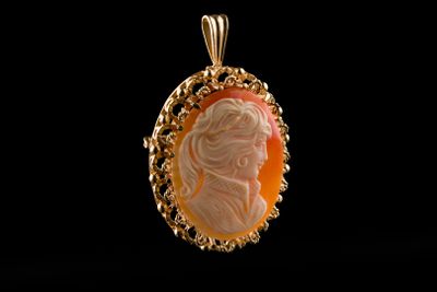 un gros plan d'un pendentif sur lequel figure le visage d'une femme
