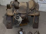 a horse saddle with a clock and other items on the floor