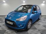 la voiture bleue est garée sur un sol en damier dans le garage