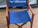 a blue director ' s chair in the middle of a gym