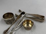 trois cuillères en argent et deux tasses en argent posées sur un plat blanc