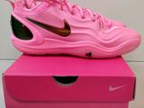 une boîte rose sur laquelle est posée une paire de chaussures