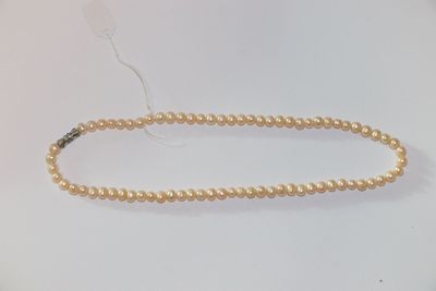 gros plan d'un collier de perles sur une surface blanche