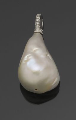 un pendentif en perle blanche et diamants sur un fond noir