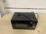 a small black microwave sitting on a counter top