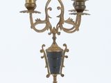 a gold and black candelab with three candles on it